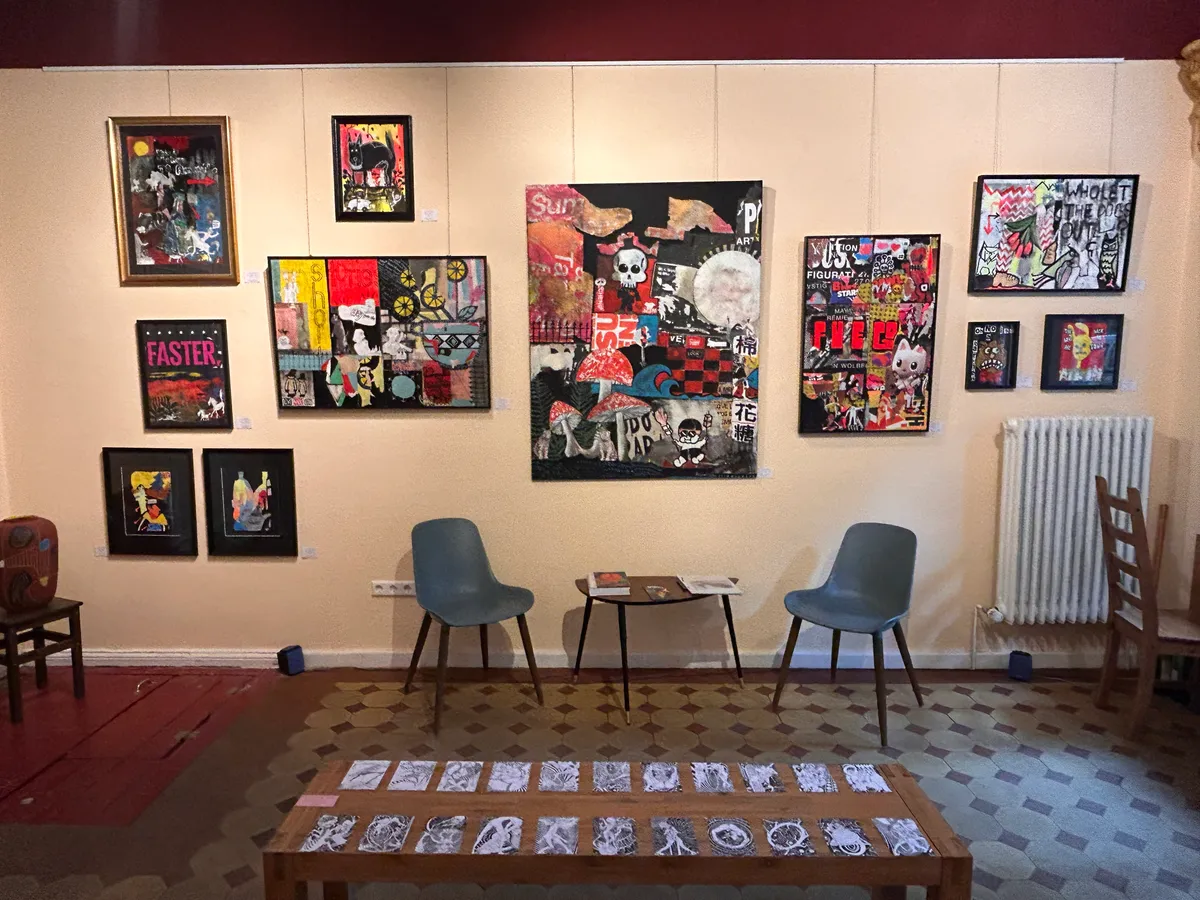Inside the gallery: paintings hung close together on the burgundy walls